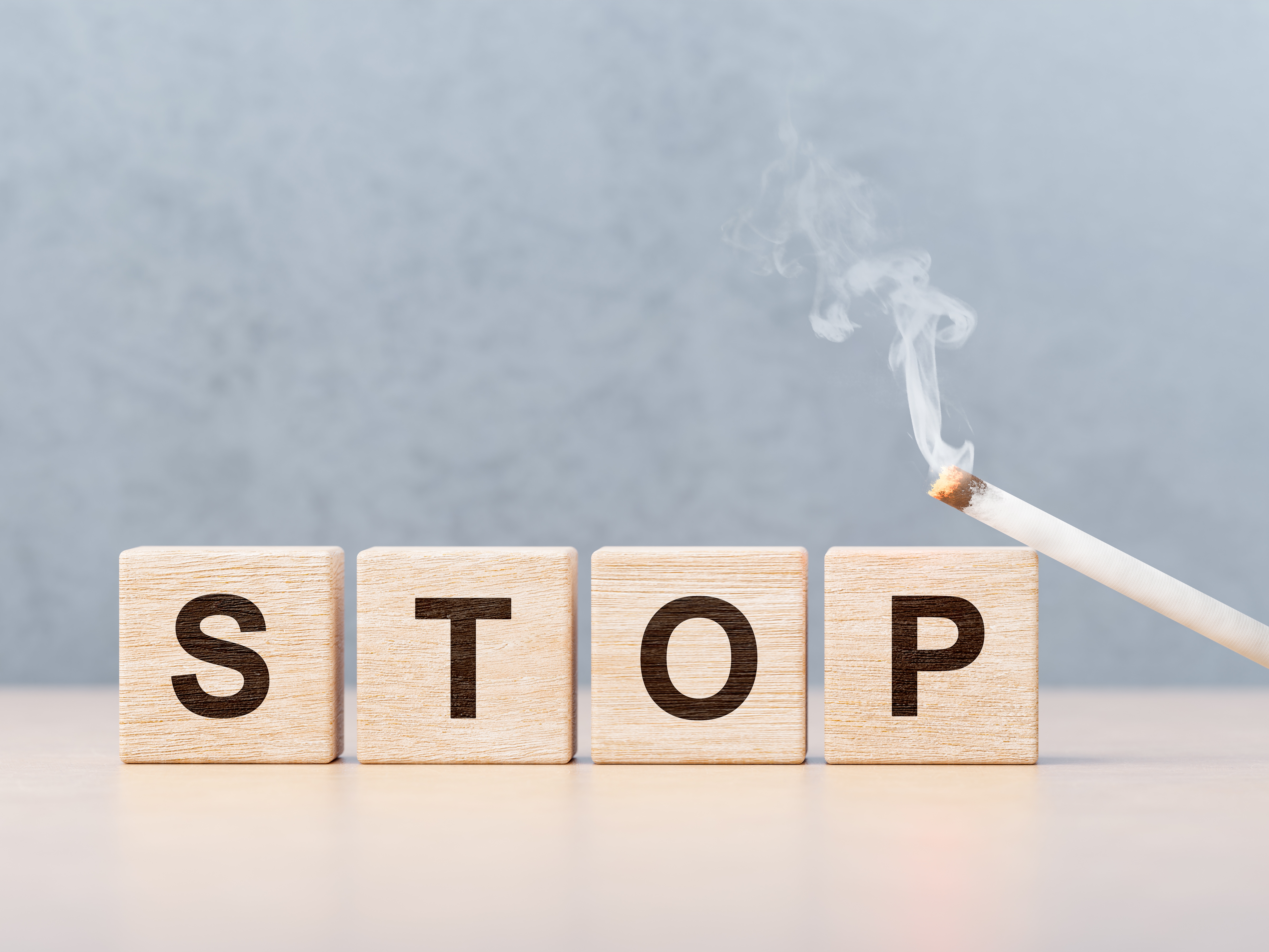wooden cubes with inscription stop and smoking cigarette. stop smoking, tobacco ban, complete ban on tobacco cigarettes. copy space