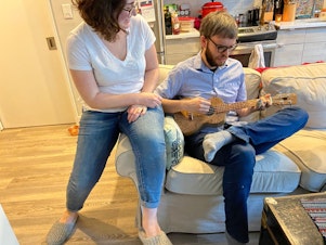 caption: Hannah Groch-Begley listens to Dylan Matthews play the ukulele at their home in Washington, D.C. Dylan had hesitated to buy the ukulele because it felt like too big of an indulgence.