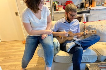 caption: Hannah Groch-Begley listens to Dylan Matthews play the ukulele at their home in Washington, D.C. Dylan had hesitated to buy the ukulele because it felt like too big of an indulgence.