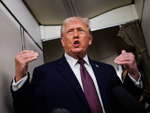 caption: President Trump takes questions from members of the press aboard Air Force One.
