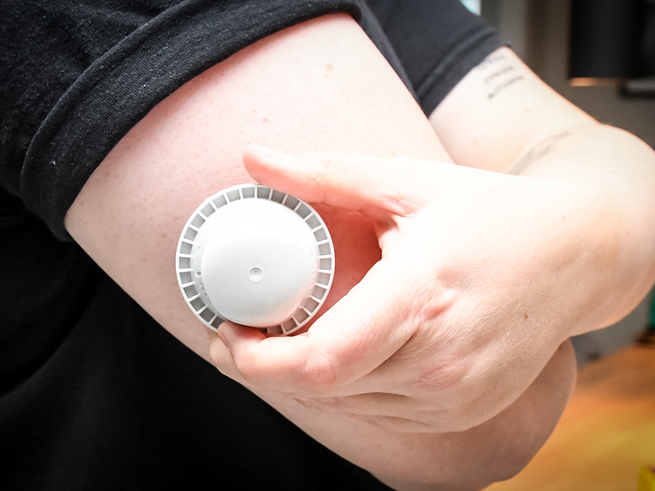 caption: A photo illustration shows the applicator of the Abbott Freestyle Libre 3 Plus glucose sensor on the arm of a patient on Thursday.