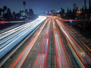 caption: Cars and trucks move slowly during evening rush hour on the Hollywood Freeway in Los Angeles, Calif. in 2014.