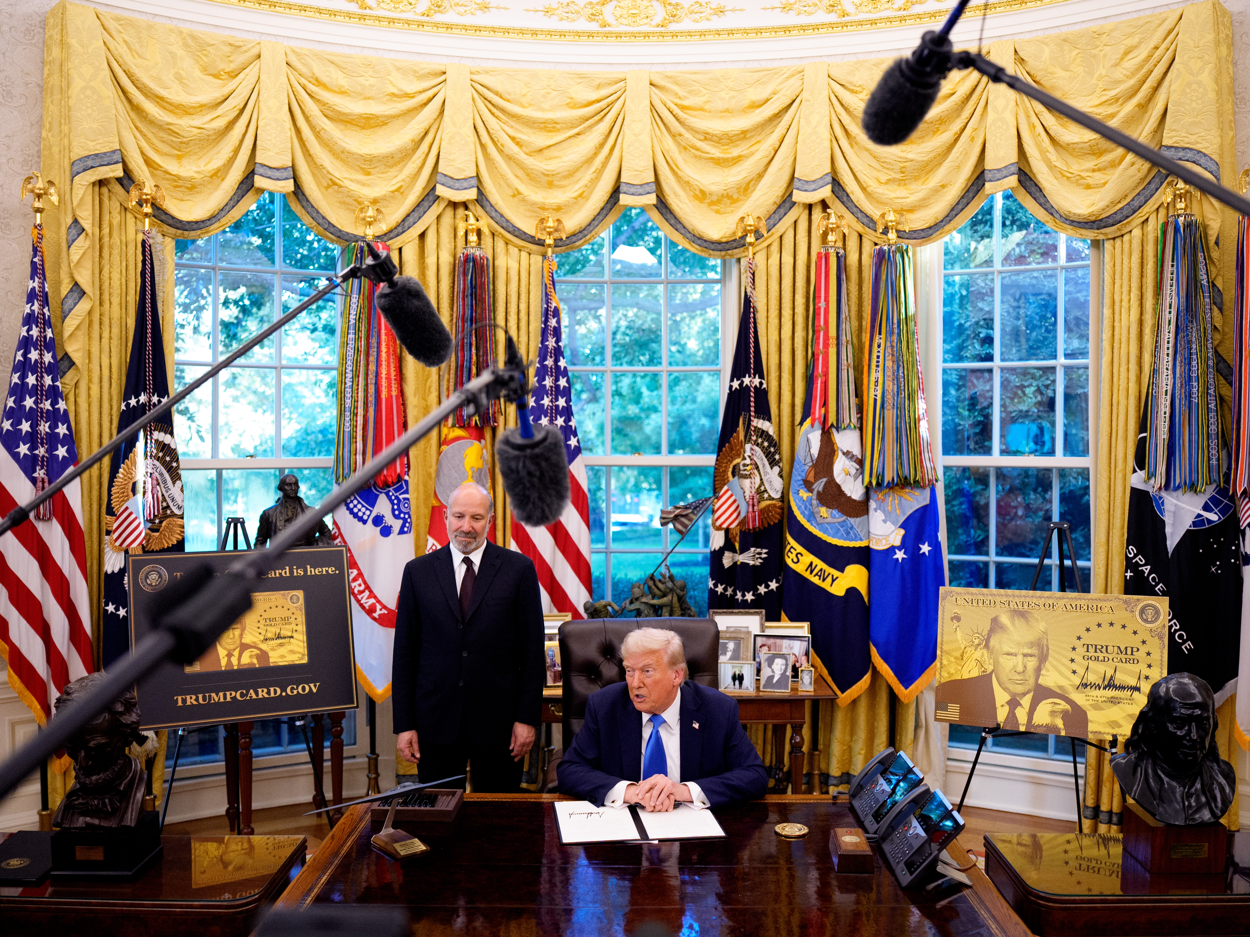 caption: President Donald Trump, accompanied by U.S. Commerce Secretary Howard Lutnick (L), speaks after signing an executive order in the Oval Office at the White House on September 19, 2025 in Washington, DC. Trump signed two executive orders, establishing the "Trump Gold Card" and introducing a $100,000 fee for H-1B visas. The "Trump Gold Card" is a visa program that allows foreign nationals permanent residency and a pathway to U.S. citizenship for a $1 million investment in the United States.