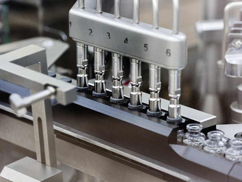 caption: Rubber stoppers are placed onto filled vials of the investigational drug remdesivir at a Gilead manufacturing site in the United States.