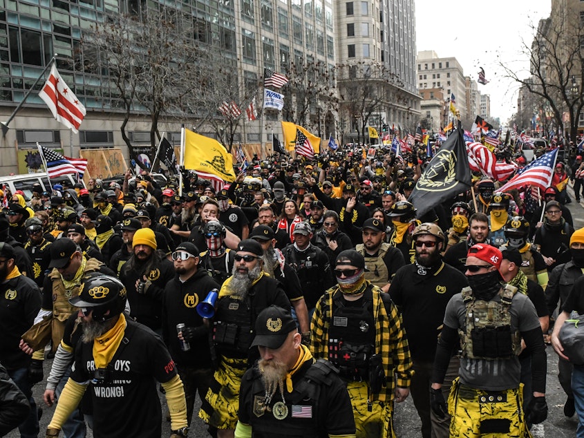 caption: Members of the Proud Boys march toward Freedom Plaza during a protest in December 2020 in Washington, D.C. The Proud Boys has been designated as a hate group by the Southern Poverty Law Center.