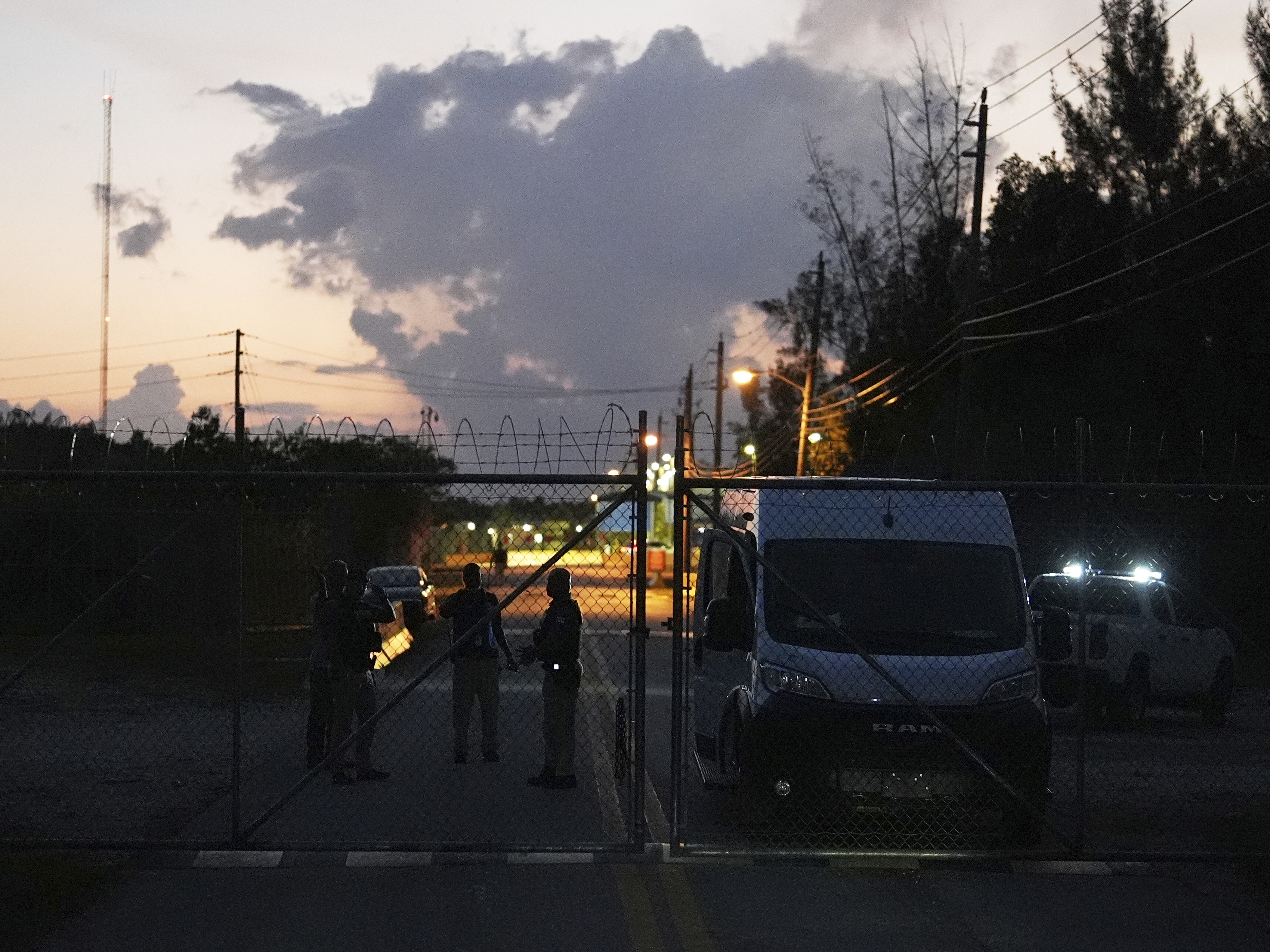 caption: Krome Detention Center officers man a gate leading to the U.S. Immigration and Customs Enforcement facility, May 24, 2025, in Miami.