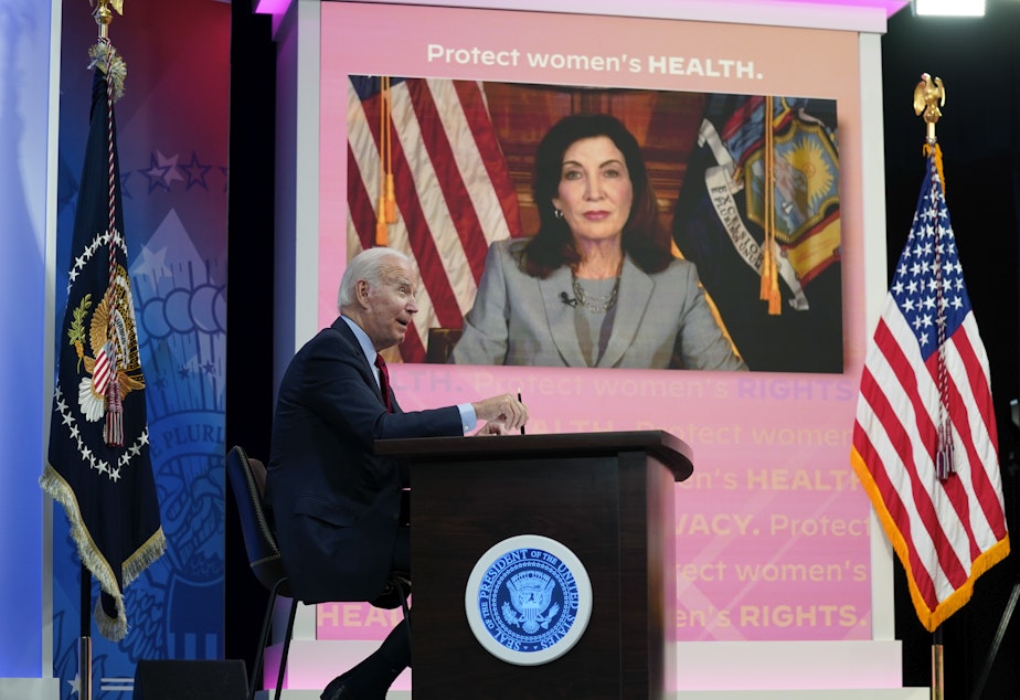 caption: President Joe Biden speaks as New York Gov. Kathy Hochul appears on a screen during a virtual meeting with Democratic governors on abortion rights on Friday.