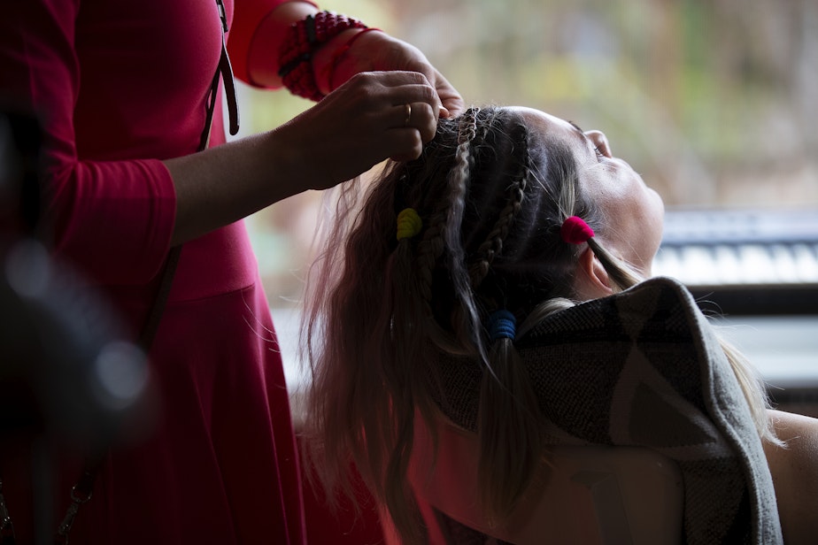 caption: Iryna has her hair braided before marrying her wife, Olena, on Saturday, April 8, 2023, at a home in Bellevue. 