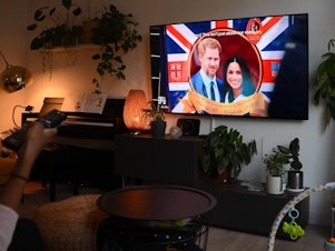caption: A woman watches an episode of the newly released Netflix docuseries <em>Harry & Meghan,</em> about Britain's Prince Harry, Duke of Sussex, and Britain's Meghan, Duchess of Sussex, in London on Thursday.