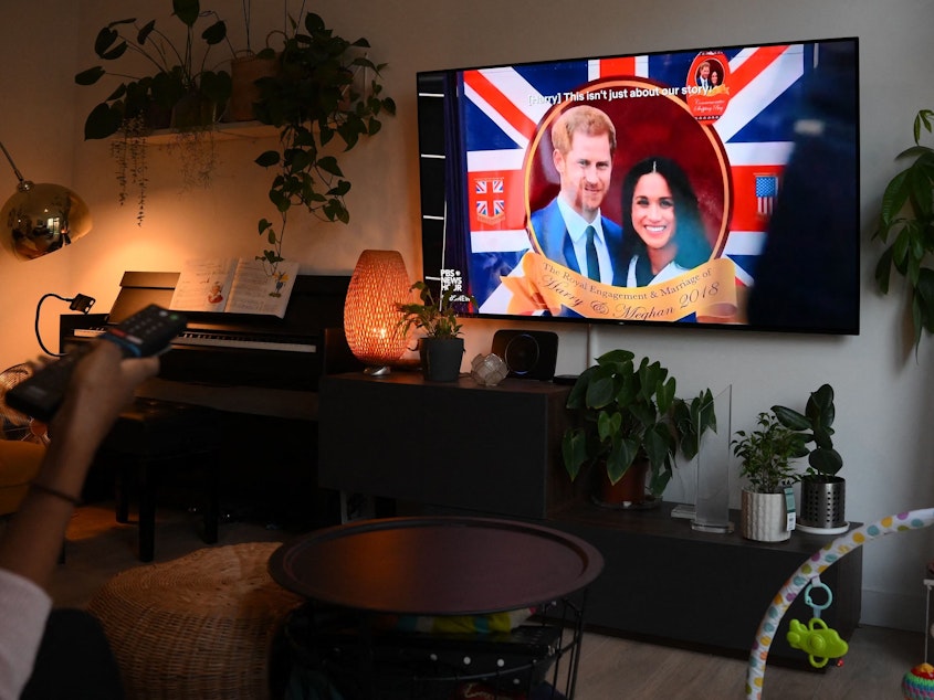 caption: A woman watches an episode of the newly released Netflix docuseries <em>Harry & Meghan,</em> about Britain's Prince Harry, Duke of Sussex, and Britain's Meghan, Duchess of Sussex, in London on Thursday.