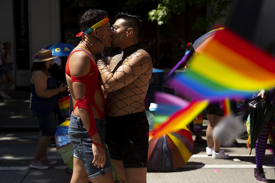 caption: Chrissy, left, and Andres, right, share a kiss while marching with Entre Hermanos, Seattle’s Latinx LGBTQ+ organization, during Seattle’s Pride Parade on Sunday, June 25, 2023, in downtown Seattle.