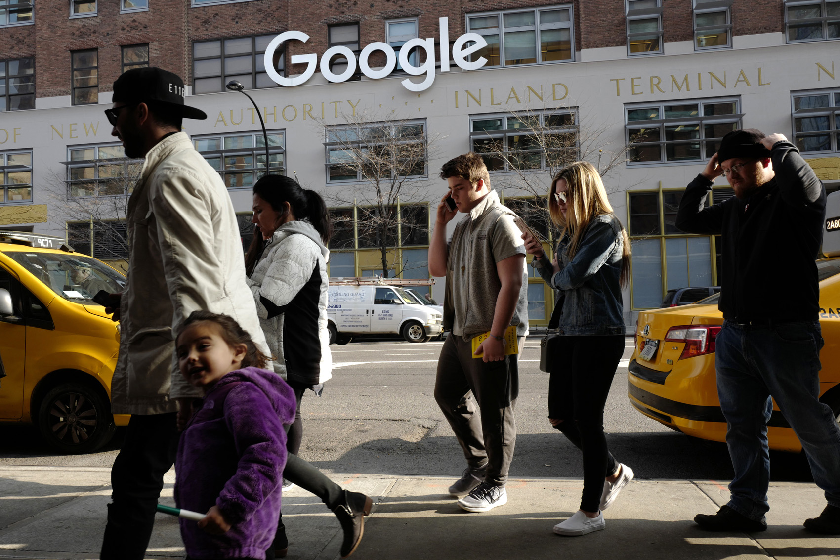 caption: FILE - In this Dec. 4, 2017, file photo, people walk by the the Google office building on Ninth Avenue in New York. (AP Photo/Mark Lennihan, File)