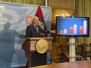 caption: Arkansas Gov. Asa Hutchinson stands next to a chart displaying COVID-19 hospitalization data as he speaks at a news conference at the state Capitol in Little Rock, Ark., Thursday, July 29, 2021.