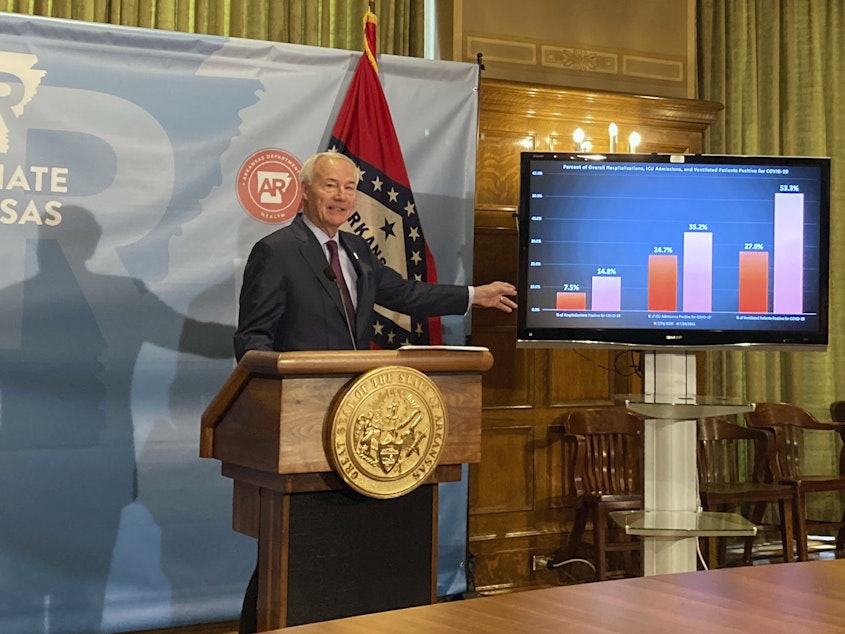 caption: Arkansas Gov. Asa Hutchinson stands next to a chart displaying COVID-19 hospitalization data as he speaks at a news conference at the state Capitol in Little Rock, Ark., Thursday, July 29, 2021.