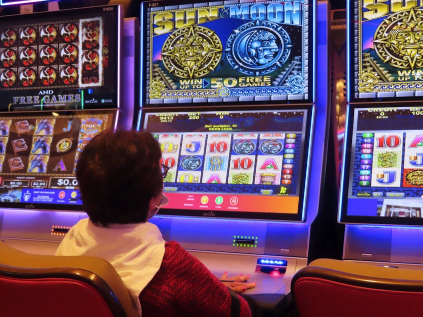 caption: A gambler plays a slot machine at the Hard Rock casino in Atlantic City, N.J. on Aug. 8, 2022.