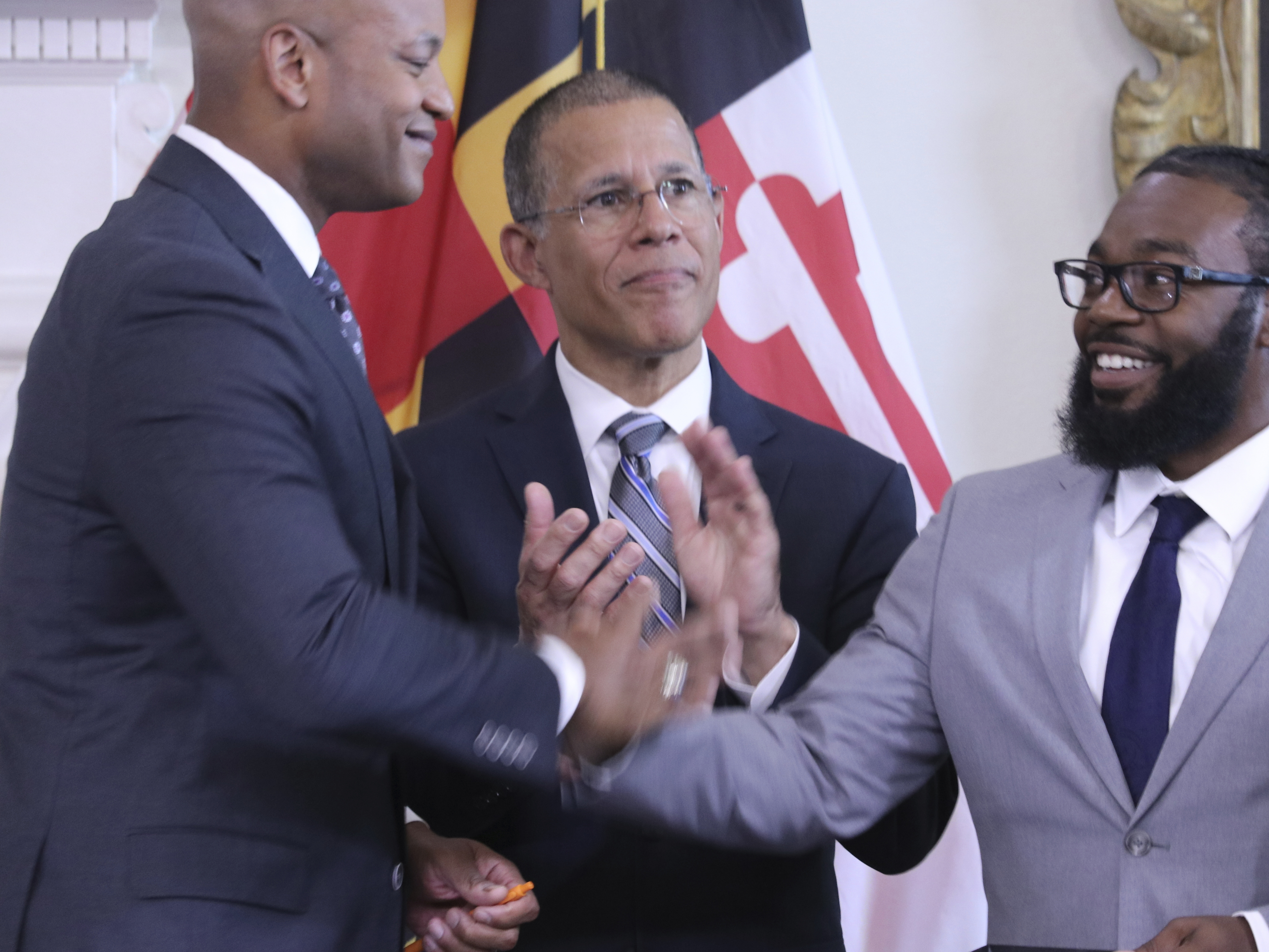 caption: Shiloh Jordan, right, who was among the people receiving a pardon for a misdemeanor marijuana conviction years ago, greets Maryland Gov. Wes Moore at a news conference in Annapolis, Md., on June 17 when Moore announced more than 175,000 pardons. Maryland Attorney General Anthony Brown is center. 