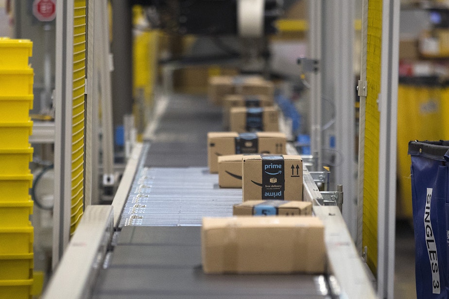 caption: Items are scanned as they travel on a conveyer belt toward the ship dock at an Amazon fulfillment center on Friday, November 3, 2017, in Kent. 
