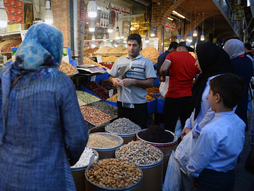 caption: The unanimous ruling from the International Court of Justice orders the U.S. to allow Iran to import food, medical supplies and other products for humanitarian reasons. Here, people browse for goods in the Grand Bazaar in Tehran.