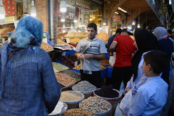 caption: The unanimous ruling from the International Court of Justice orders the U.S. to allow Iran to import food, medical supplies and other products for humanitarian reasons. Here, people browse for goods in the Grand Bazaar in Tehran.