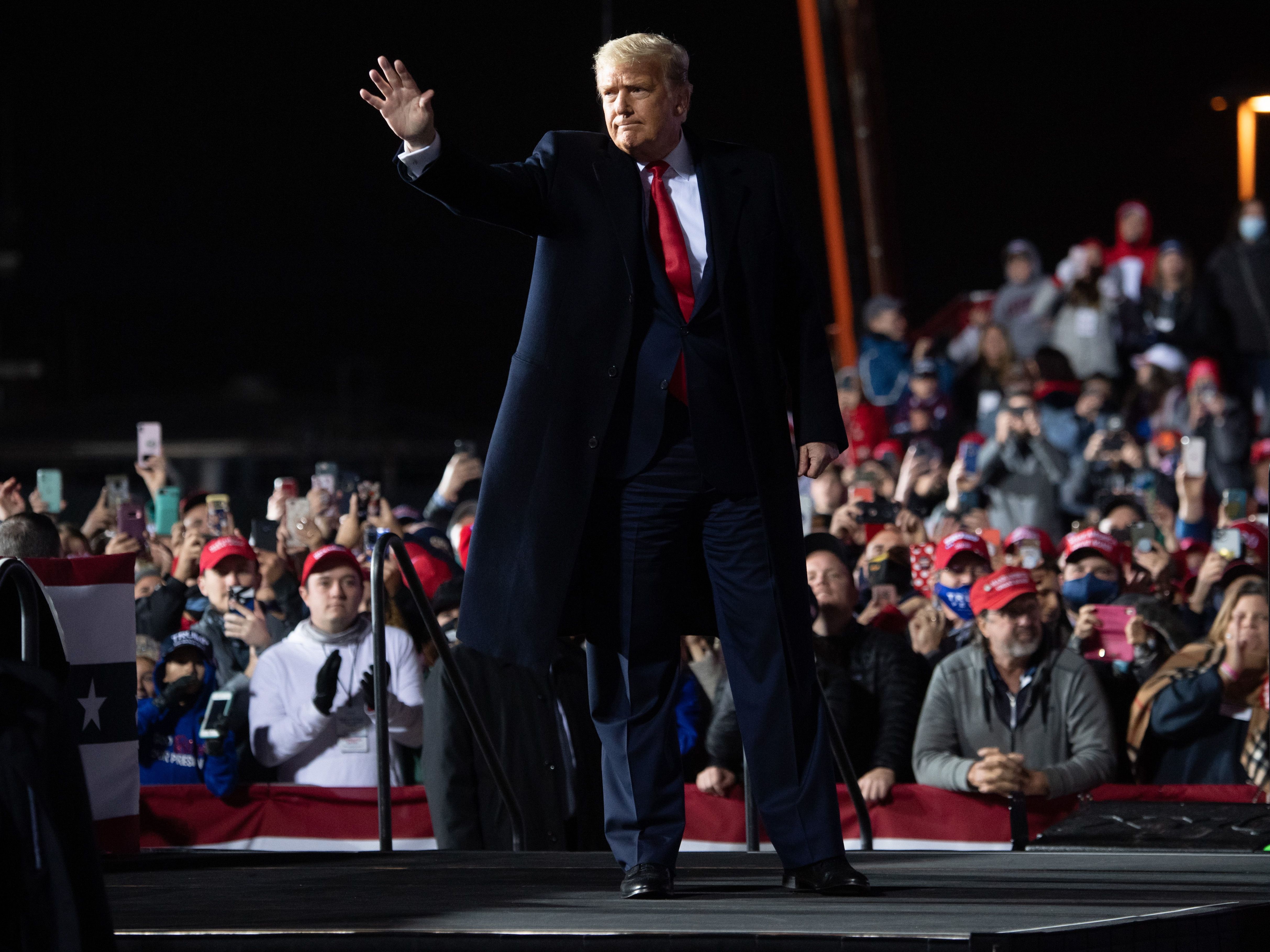 caption: President Trump waves at the end of a rally at Erie International Airport in Erie, Pa., on Tuesday evening.
