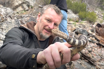 caption: Chris holding a Northern Pacific rattlesnake. The age of a snake can be determined by the number of coils on their rattlers.
