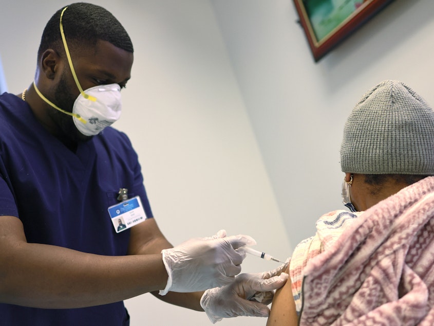 caption: Kurtis Smith gives the Moderna coronavirus vaccine to a resident at Red Hook Neighborhood Senior Center in Brooklyn, N.Y., on Monday.