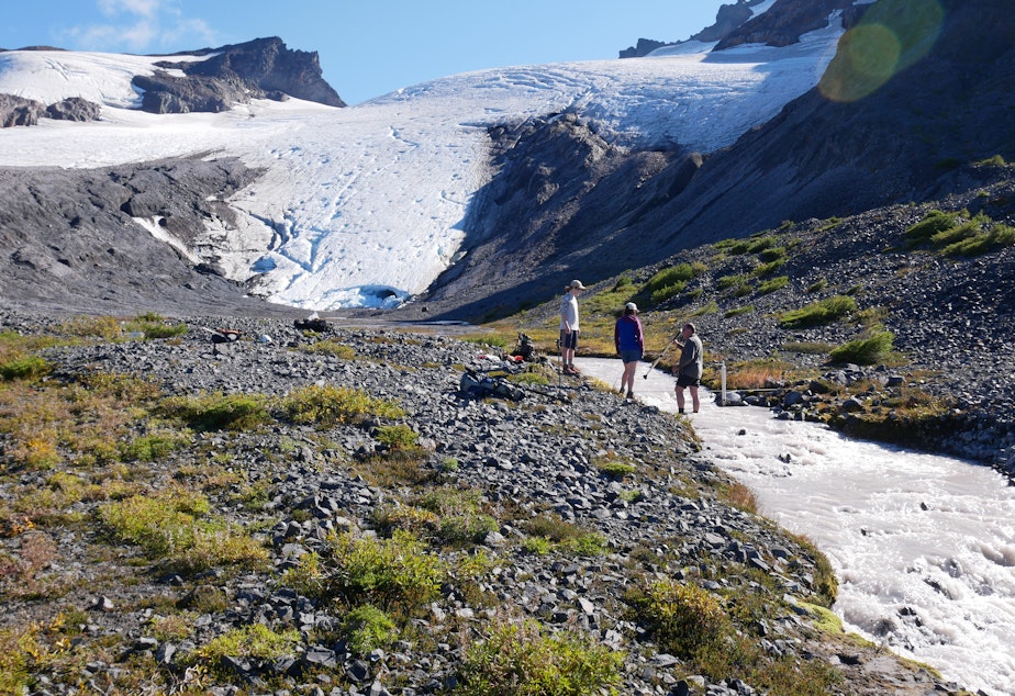 caption: Researchers for the Nooksack Tribe document the flow of Sholes Creek from the Sholes Glacier on Mount Baker.