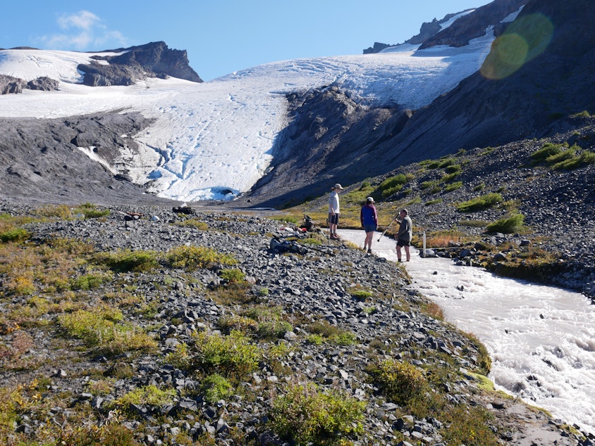 caption: Researchers for the Nooksack Tribe document the flow of Sholes Creek from the Sholes Glacier on Mount Baker.