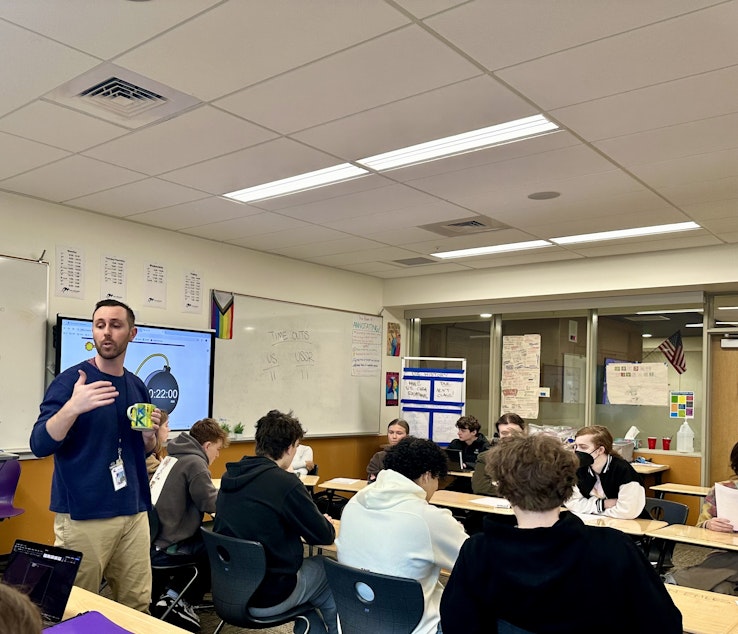 caption: Sean Mullin gives his students instruction before they start their simulation of the Cuban Missile Crisis negotiations. Students used AI to help them prepare for the discussion.