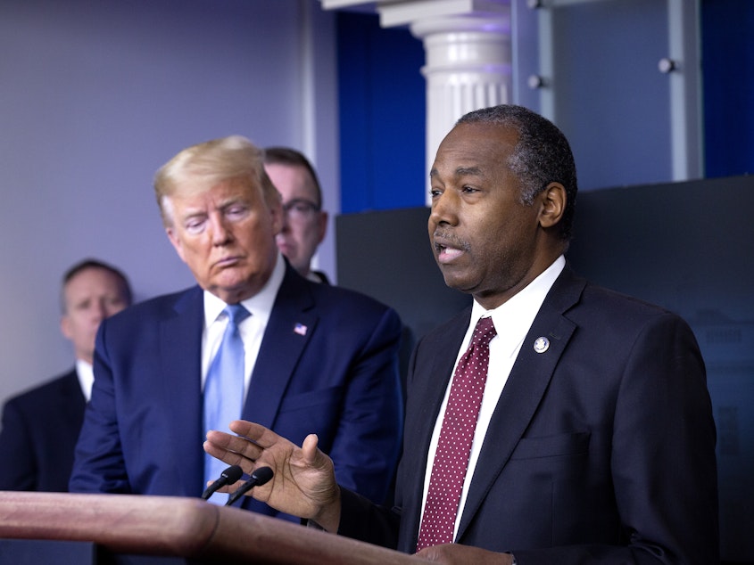 caption: Ben Carson, secretary of Housing and Urban Development, right, speaks during a Coronavirus Task Force news conference in the briefing room of the White House in March.
