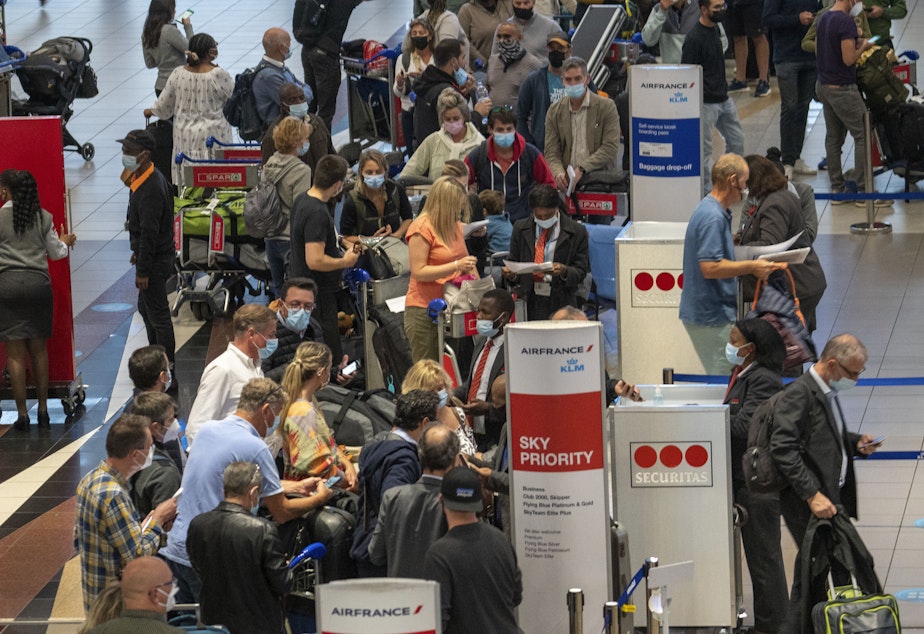caption: People line up to get on the Air France flight to Paris at OR Tambo's airport in Johannesburg, South Africa, on Nov. 26. The United States, Israel and other European nations have already imposed travel restrictions on South Africa and other nations in the region.