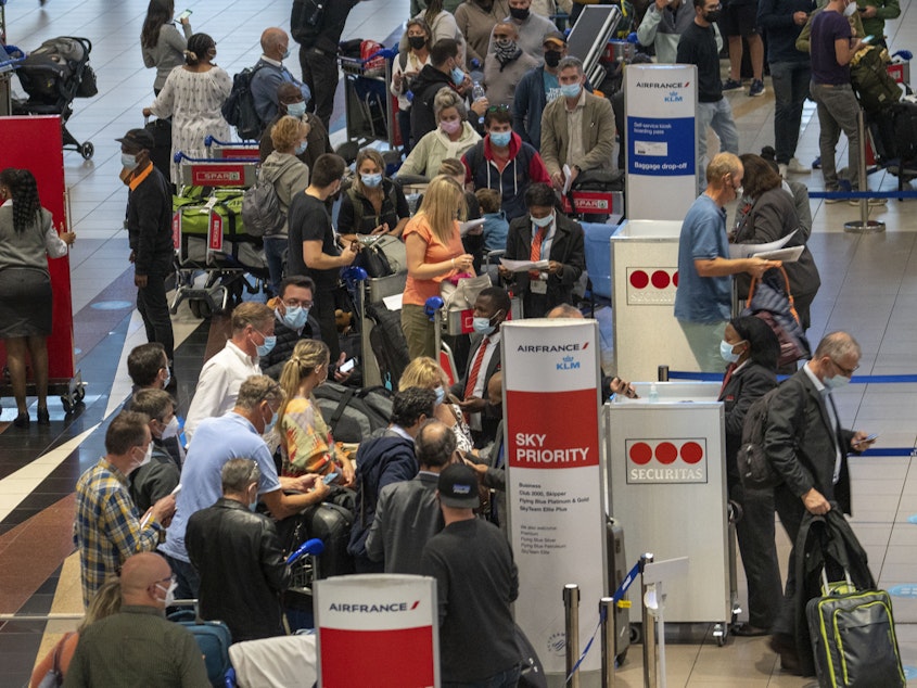 caption: People line up to get on the Air France flight to Paris at OR Tambo's airport in Johannesburg, South Africa, on Nov. 26. The United States, Israel and other European nations have already imposed travel restrictions on South Africa and other nations in the region.