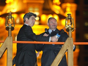 caption: Allen Weisselberg (right), the longtime chief financial officer of the Trump Organization, lights a Hanukkah menorah with then-Macy's CEO Ron Klein in 2004 in New York City.