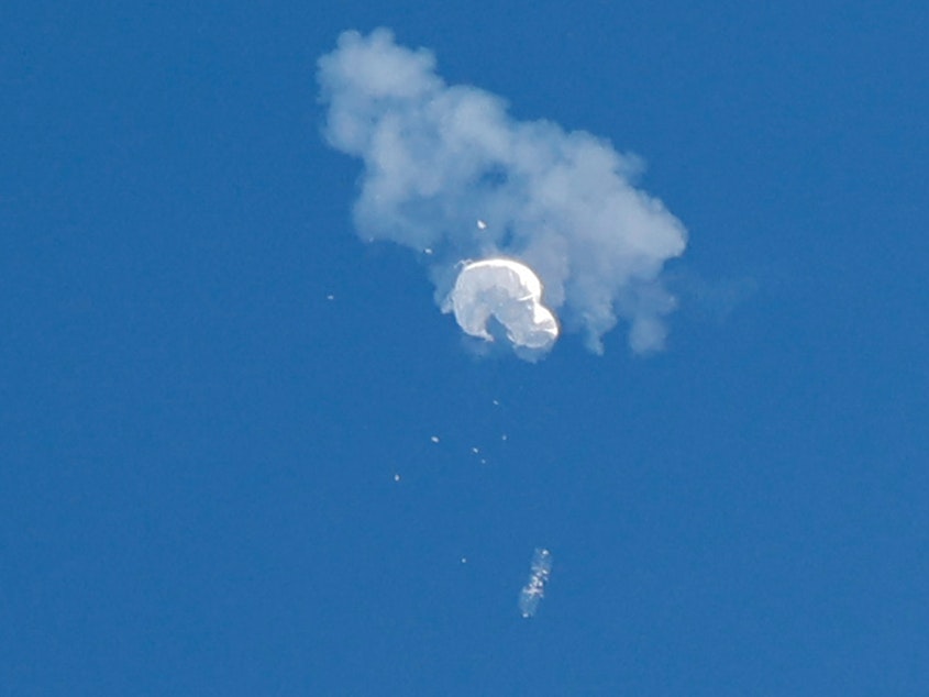 caption: The suspected Chinese spy balloon drifts to the ocean after being shot down off the coast in Surfside Beach, S.C., on Saturday.