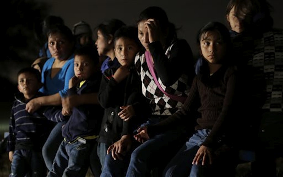 caption: In this June 25, 2014 photo, a group of immigrants from Honduras and El Salvador who crossed the U.S.-Mexico border illegally are stopped in Granjeno, Texas. 