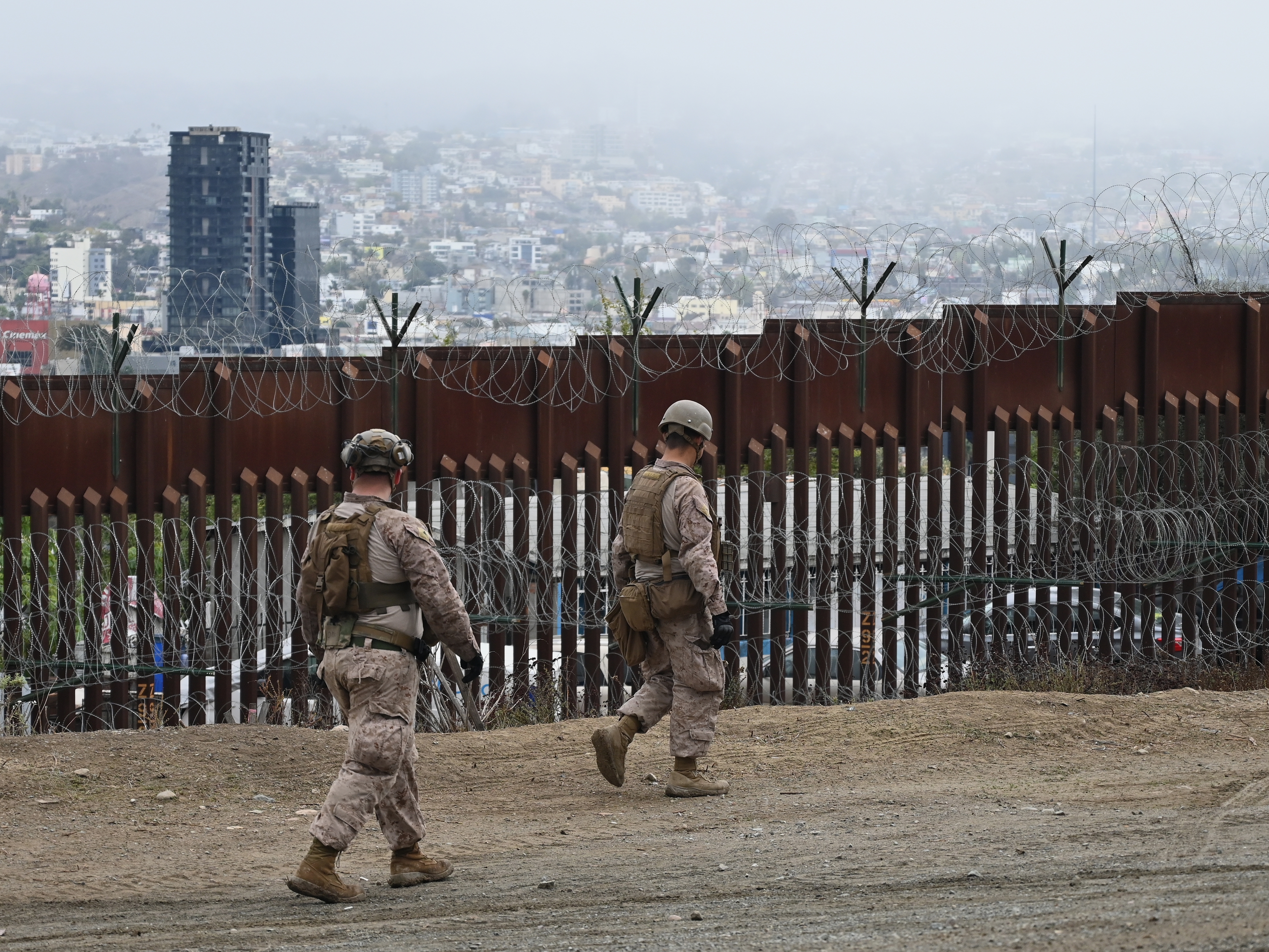caption: Members of the U.S. Marine Corps patrol the U.S.-Mexico border area as seen from San Diego on Feb. 7.