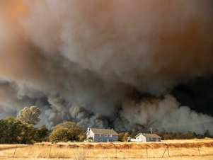 caption: Towering smoke plumes overshadowed California's town of Paradise as the Camp Fire raced through in 2018. More than 18,000 acres burned in a matter of hours.