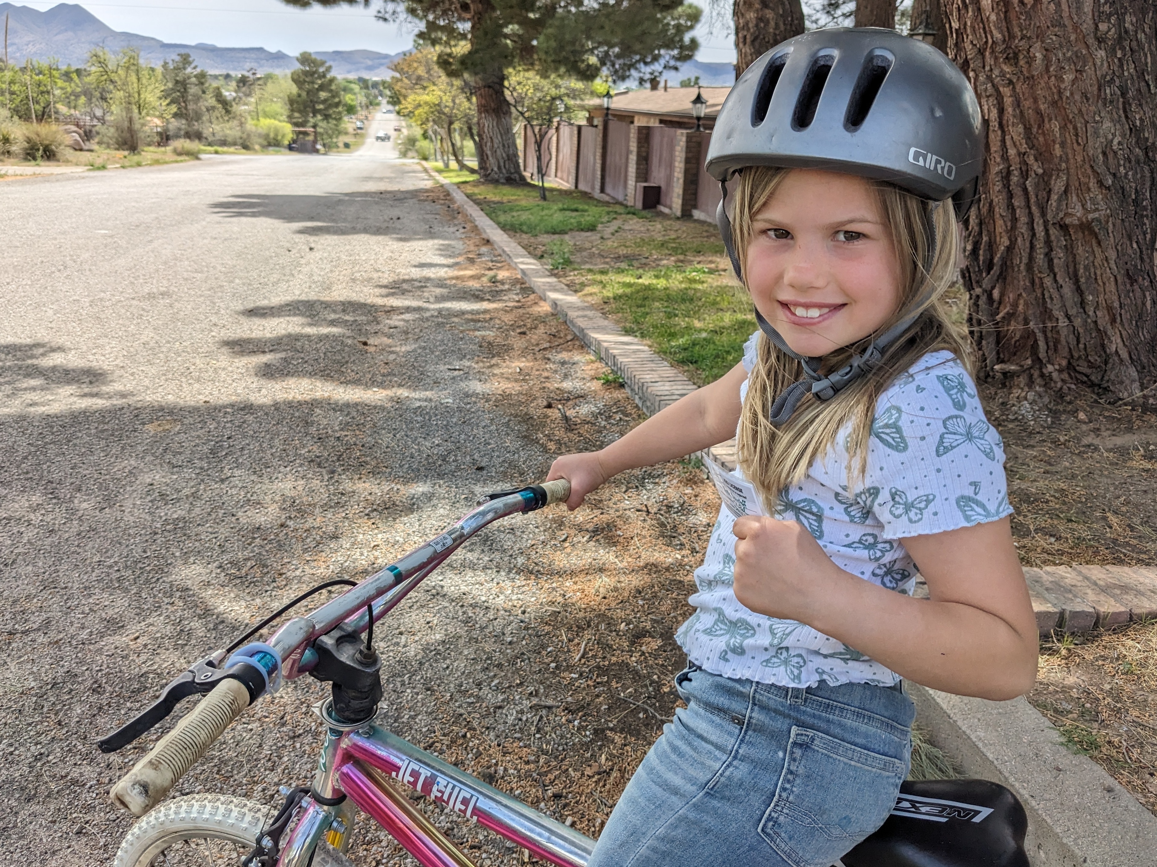 caption: The author's 8-year-old daughter Rosy has a 'kids' license,' showing she has her parents' permission to ride her bike around her Texas hometown.