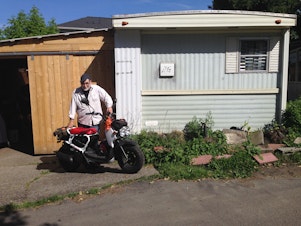 caption: Dave Martin stands outside his home in a trailer park on Lake City Way.