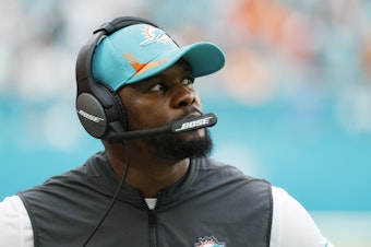 caption: Former head coach Brian Flores of the Miami Dolphins looks on from the side line during the game against the New York Jets at Hard Rock Stadium on Dec. 19, 2021 in Miami Gardens, Fla.