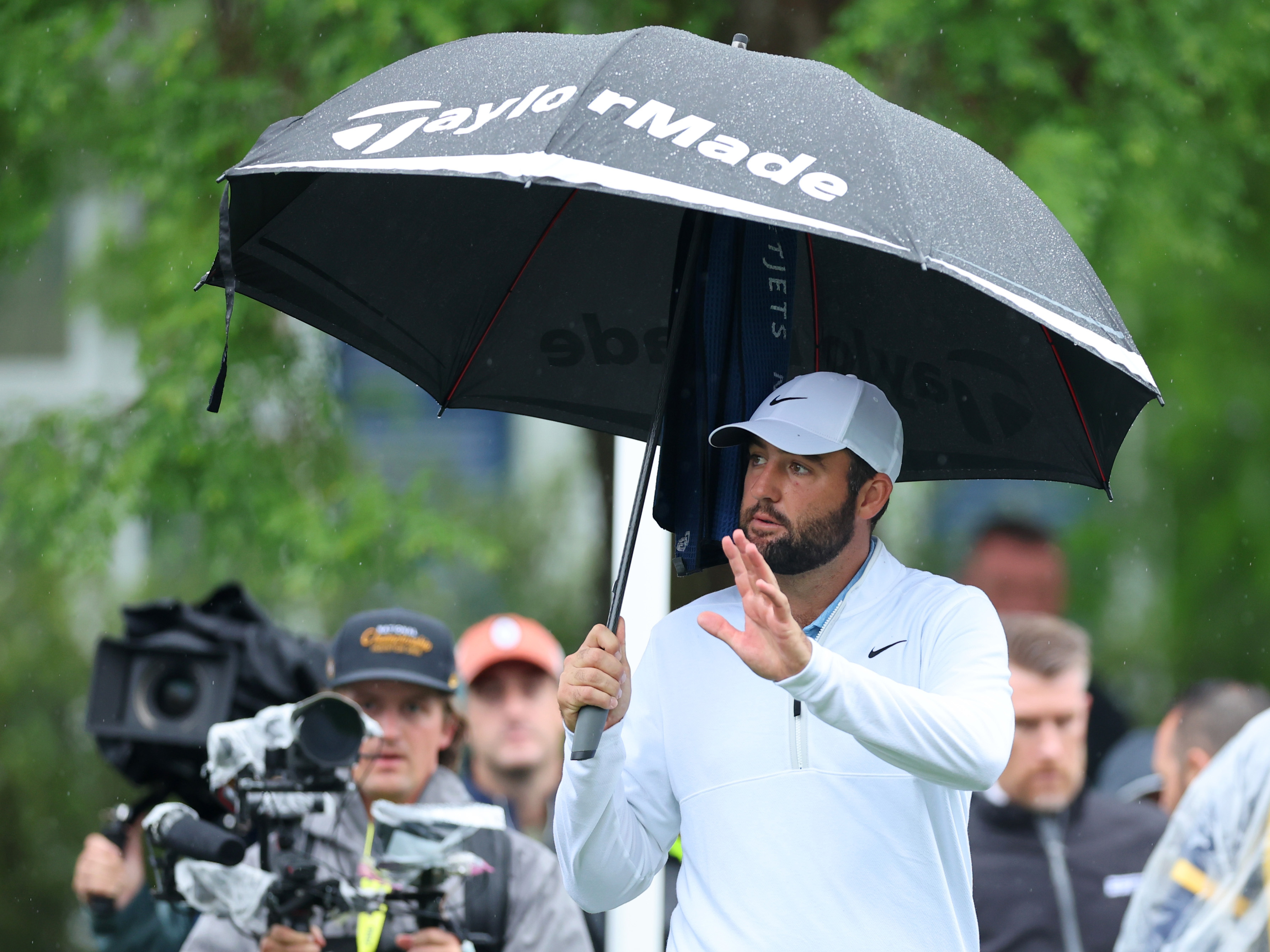 caption: Scottie Scheffler reacts before teeing off Friday on during the second round of the 2024 PGA Championship at Valhalla Golf Club in Louisville, Ky. Scheffler was arrested and charged after an interaction early Friday morning with a police officer directing traffic into to the club.