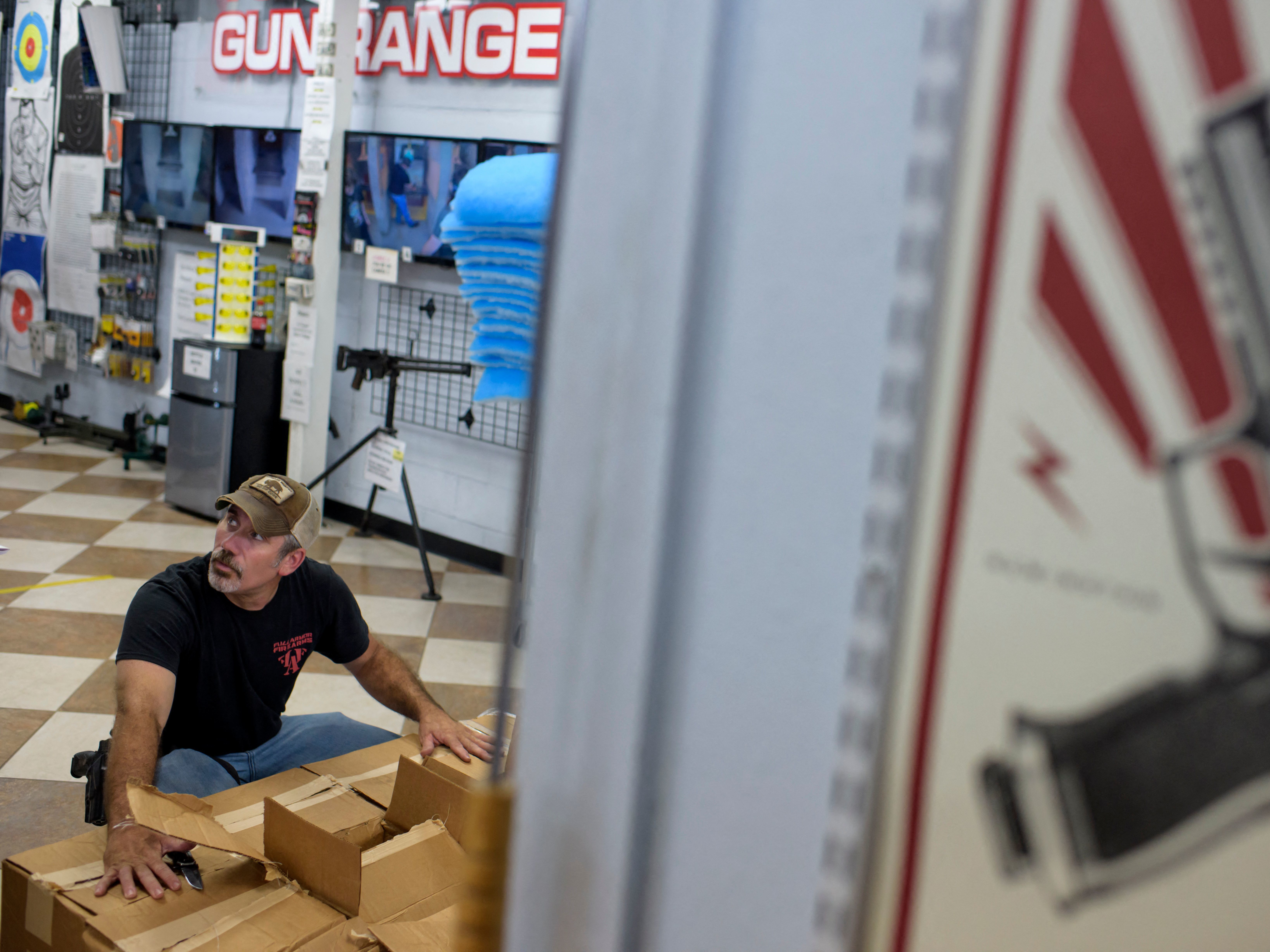 caption: Employee Curt Hubbard unloads a shipment of ammunition at Full Armor Firearms in Houston, Texas on June 17, 2021.