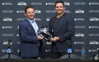 caption: Seattle Seahawks general manager John Schneider poses with the team's new head coach, Mike Macdonald, on Feb. 1, 2024. 
