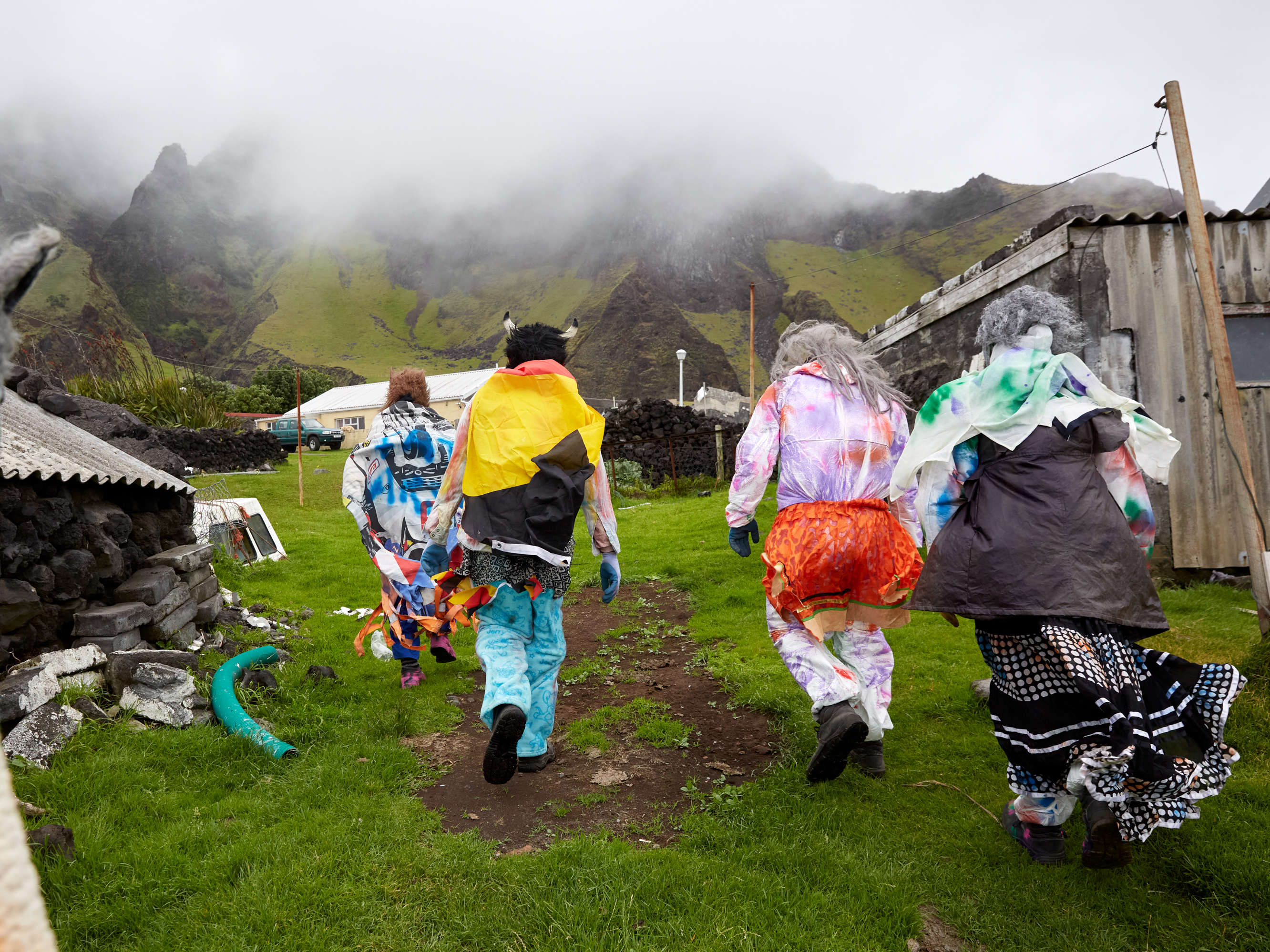 caption: A group of Okalolies head toward a house belonging to one of their own in Edinburgh of the Seven Seas on Tristan da Cunha, in the South Atlantic Ocean, on Dec. 31, 2023. New Year's Eve, or Old Year's Night as it's known on the island, is a chance for the whole community to come together.