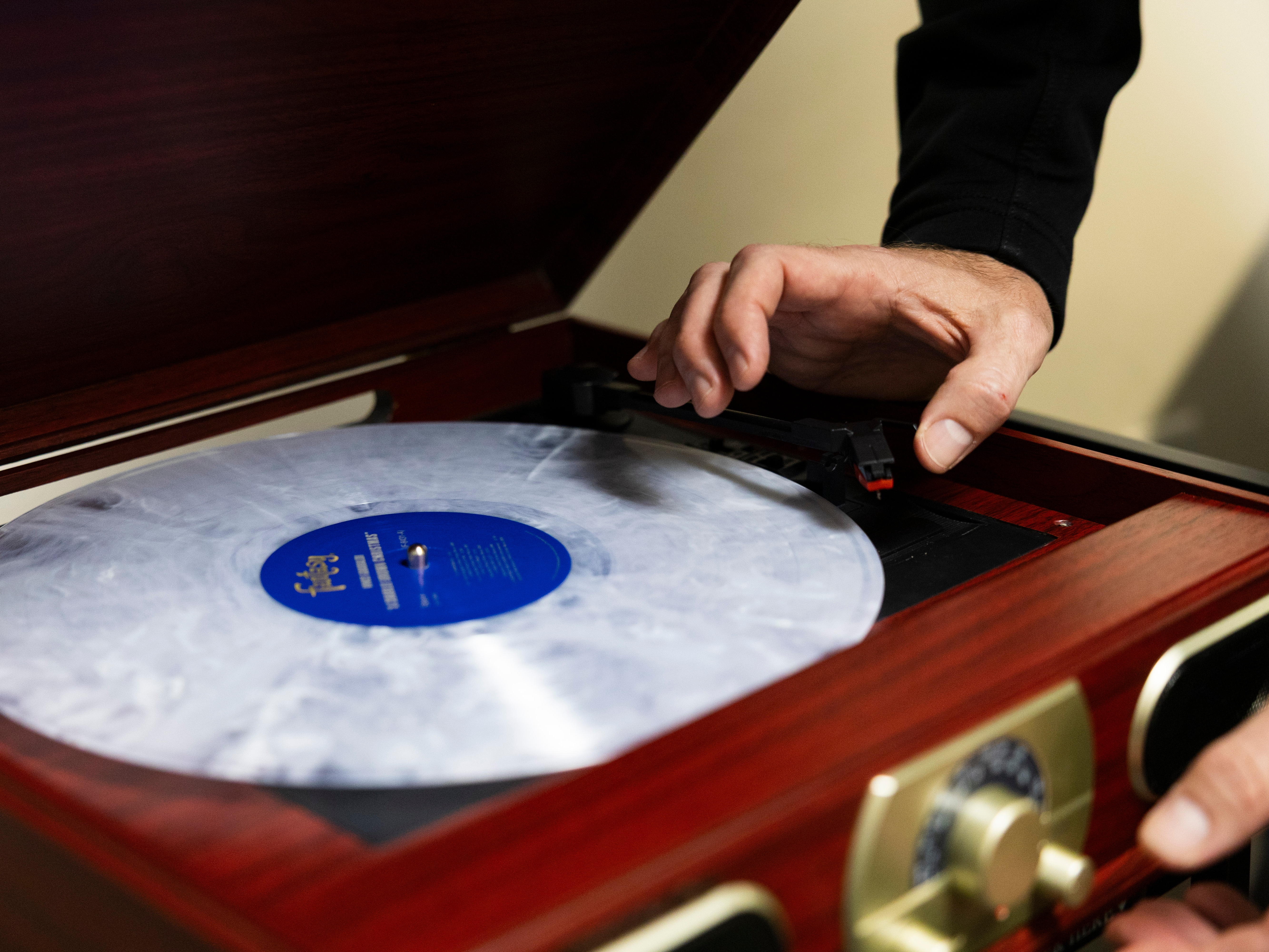 caption: Dr. Tyler Jorgensen sets "A Charlie Brown Christmas" on a record player at Dell Seton Medical Center in Austin Texas. He uses vinyl records as a form of music therapy for palliative care patients.