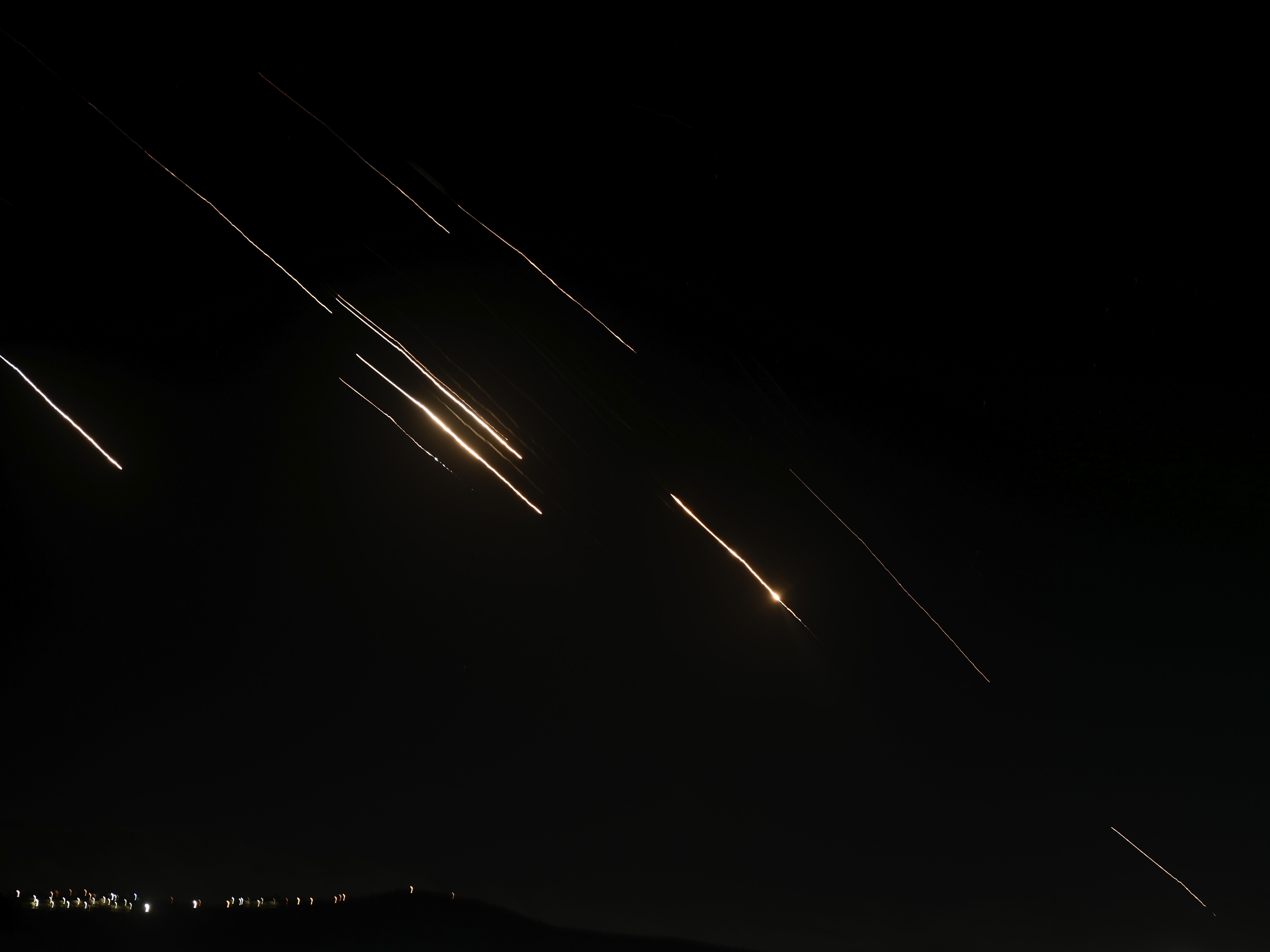caption: Missiles launched from Iran towards Israel are seen in the West Bank city of Nablus Tuesday, Oct. 1, 2024.