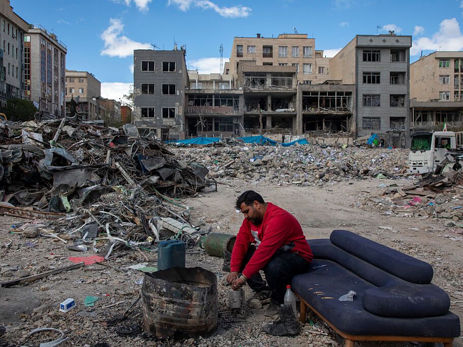 caption: A man sits among buildings destroyed in a joint attack by Israel and the United States in Tehran, Iran, Monday.
