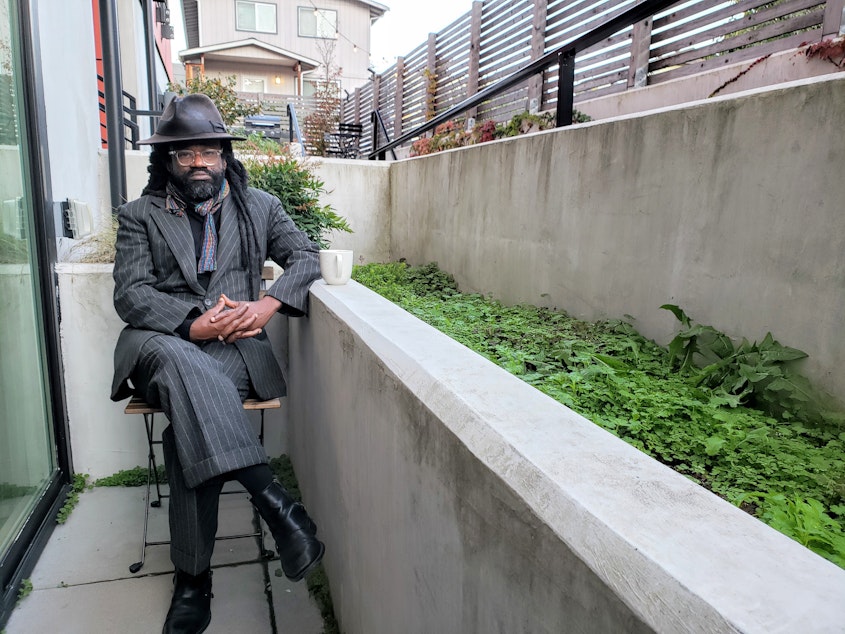 caption: Reverend Osagyefo Sekou sits outside of his Seattle apartment days before he leads a non-violent, civil disobedience training. Thursday, October 29, 2020.