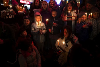 caption: A large crowd led by Jewish Voice for Peace - Seattle gathered to light candles on the second night of Hanukkah, or Chanukah, and call for an immediate ceasefire in Gaza on Friday, December 8, 2023, at Pike Place Market in Seattle. 