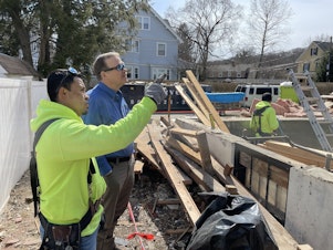 caption: Builder Emerson Claus and his foreman Rene Landeverde at the site of an apartment they are building in a suburb of Boston.